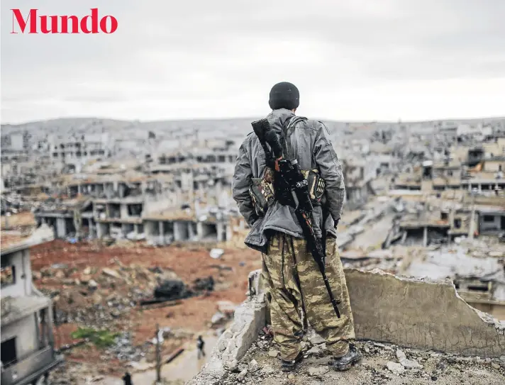  ?? FOTO: AFP ?? Musa, un joven kurdo de 25 años, vigila y observa desde un edificio la destrucció­n de Kobane el viernes pasado.