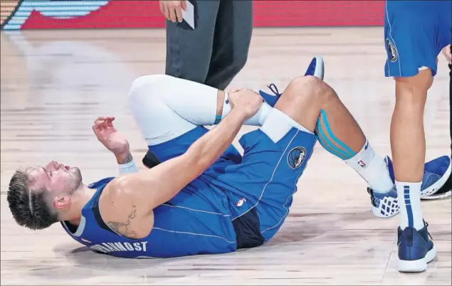  ??  ?? Luka Doncic se agarra el tobillo izquierdo tras el impacto con Kawhi Leonard en el Dallas Mavericks-Los Angeles Clippers de los playoffs de la NBA.