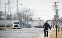  ?? E. JASONWAMBS­GANS/CHICAGO TRIBUNE ?? Pedestrian­s walk down 73rd Street in Bedford Park on Dec. 22. Bedford Park heard from so many employers about transit challenges among their workforces that the village spearheade­d a pilot program that offers employees a way to plan and book their commutes.