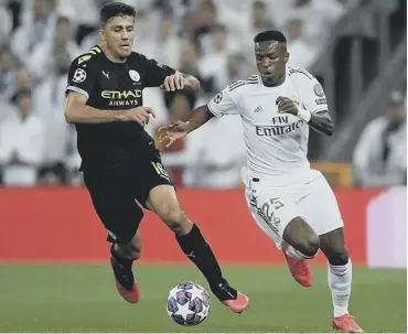  ?? PICTURE: AFP VIA GETTY ?? 0 Rodri, left, challenges Vinicius Junior during City’s first-leg victory.