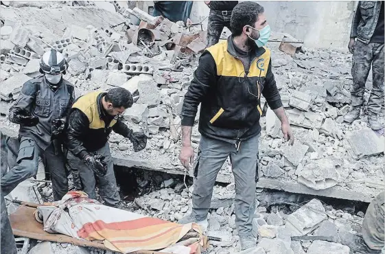  ?? SYRIAN CIVIL DEFENSE THE ASSOCIATED PRESS ?? Members of the White Helmets volunteer organizati­on remove a body after airstrikes and shelling by Syrian government forces in Ghouta, a suburb of Damascus, Syria.