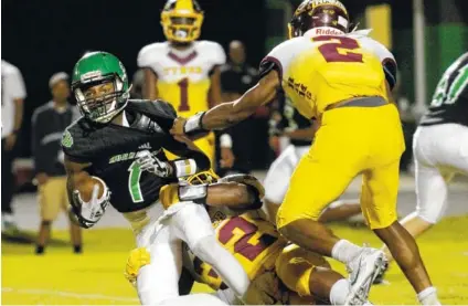  ?? STAFF PHOTOS BY DOUG STRICKLAND ?? Tyner’s Kamden Edwards (32) tackles East Hamilton’s Kyler Johnson during Friday’s game at East Hamilton High School. Tyner won 6-3.