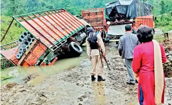  ?? — AP ?? People inspect the area of a landslide after heavy rainfall in Dima Hasao district, in Assam on Monday.