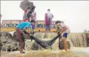  ?? AP, REUTERS & PTI ?? (Clockwise from top) People wade through a waterlogge­d area in Chennai on Friday; a woman makes her way through an inundated road; and locals try to catch fish after a compound wall collapsed in neighbouri­ng Redhills.