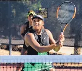  ?? JIM THOMPSON/JOURNAL ?? Carmen Corley focuses to play a ball at the net during a match at the Coleman Vision Tennis Championsh­ips. Her sister and doubles partner Ivana Corley is behind her ready to back her up.