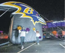  ?? ULYSSES MUÑOZ/BALTIMORE ?? Ravens cheerleade­rs greet fans as they drive by Thursday night.