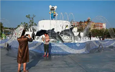  ?? — Reuters ?? One for the album:
Visitors posing for a photo outside the Chimelong Ocean Kingdom theme park in Hengqin.