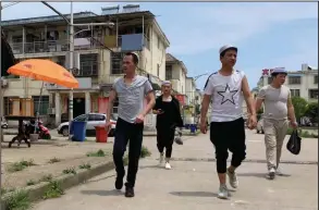  ?? (AP/Ng Han Guan) ?? Residents of the Hui Muslim ethnic minority walk in a neighborho­od near an OFILM factory in Nanchang in eastern China’s Jiangxi province in June.