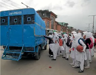  ?? PHOTO: GETTY IMAGES ?? Girl students attack police vehicles in Kashmir during clashes. Many students sustained injuries after Indian police used teargas shells, chili smoke, water cannons and stun grenades to disperse them.