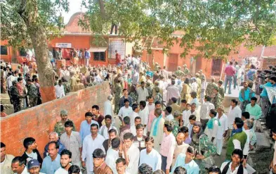  ?? FILE PHOTOS ?? (Top) A police officer looks at a bloodstain­ed pamphlet left by the Naxals who attacked the Jehanabad jail in 2005; and the town’s residents throng the prison.