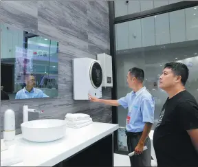  ?? PROVIDED TO CHINA DAILY ?? Visitors look at a “smart mirror”, which can monitor people’s skin conditions, at the smart home products center of leading Chinese home appliance maker Midea Group in Foshan, South China’s Guangdong province.