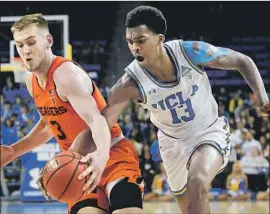  ?? Kelvin Kuo Associated Press ?? KRIS WILKES of UCLA tries to swipe the ball from Oregon State’s Tres Tinkle in the first half Thursday. Tinkle had 19 points and 16 rebounds for the Beavers.