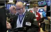  ?? RICHARD DREW — THE ASSOCIATED PRESS FILE ?? Jeffrey Vazquez, center, works on the floor of the New York Stock Exchange. U.S. stocks rose Tuesday as industrial and technology companies recovered some of the big losses they took over the last month.