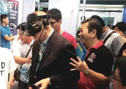  ?? SUN.STAR FOTO / ALLAN CUIZON ?? NEW LEVEL OF EXPERIENCE: Science and Technology Secretary Fortunato dela Peña (left) tries on the virtual reality technology during his visit at the opening of the 2019 Cebu Innovation Expo. With him is Felix Taguiam (right) the 2019 Cebu Business Month adviser.