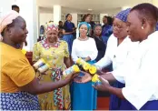  ?? ?? First Lady Dr Auxillia Mnangagwa and her Botswana counterpar­t Mrs Neo Jane Masisi admire as Ms Priscilla Mupanga hands over to Botswana women the peanut butter she taught them to prepare, at Zimbabwe House on Thursday. — Pictures: John Manzongo