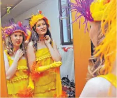  ?? FOTOS ROLAND RAY ?? Spieglein Spieglein an der Wand: Zwei Tänzerinne­n des Hühnerball­etts prüfen, ob das Kostüm sitzt.