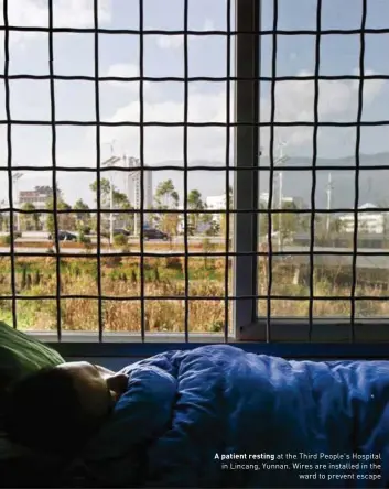  ??  ?? A patient resting at the Third People's Hospital in Lincang, Yunnan. Wires are installed in the ward to prevent escape