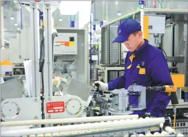  ?? PHOTOS PROVIDED TO CHINA DAILY ?? A technician with Shengrui Transmissi­on examines a front-drive eight-gears auto transmissi­on unit produced by the company. Located in the Weifang Hi-tech Industrial Developmen­t Zone, the company is a winner of the National Science and Technology...