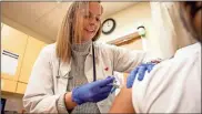  ?? Tyger Williams/tns ?? Kelly Moran, a nurse practition­er from southern Philadelph­ia, gives a flu shot to a patient at a CVS Minute Clinic in January.