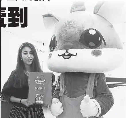  ??  ?? 唐笑宇展示公司吉祥物——松鼠。