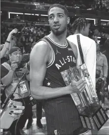  ?? AP ?? Indiana Pacers guard Tyrese Haliburton carries the championsh­ip trophy after the East defeated the West 211-186 in the NBA All-Star Game in Indianapol­is on Sunday.