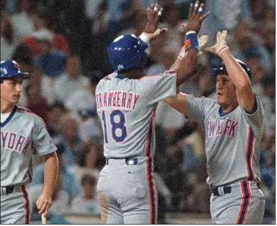  ?? (AP file photo) ?? Former New York Mets left fielder Kevin McReynolds (right) is congratula­ted by teammate Darryl Strawberry after hitting a two-run home run in a 1988 game. McReynolds, a North Little Rock native who won the Southwest Conference’s first triple crown at Arkansas in 1980, played 11 seasons in the major leagues and was known for his versatilit­y.