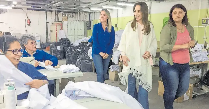  ??  ?? Recorrida. La gobernador­a María Eugenia Vidal ayer en una visita a una cooperativ­a textil en Avellaneda junto a Gladys González, senadora de Cambiemos.