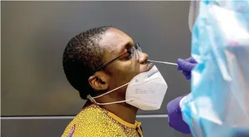  ?? — Reuters ?? Kingsley Inyang is tested as passengers arrive at Toronto’s Pearson airport after mandatory coronaviru­s testing took effect for internatio­nal arrivals in Mississaug­a, Ontario, Canada.