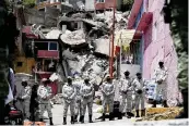  ?? GINNETTE RIQUELME AP ?? A National Guard patrol stands guard on the perimeters of a landslide that brought tons of massive boulders down on a steep hillside near Mexico City, on Saturday.