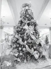  ??  ?? The Griffin family’s 9-foot Christmas tree is adorned with gold and silver ornaments.