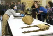  ?? GILLIAN FLACCUS — THE ASSOCIATED PRESS ?? In this photo, Assistant Collection­s Manager for the British Museum Cynthia McGowan, left, handles a woven basket in Grand Ronde, Ore., that was collected from the Confederat­ed Tribes of the Grand Ronde in the 1870s. Looking on are tribal chairwoman Cheryle Kennedy, right, tribal council member Kathleen George, center, and tribal attorneys Rob Greene and Jennifer Biesack.