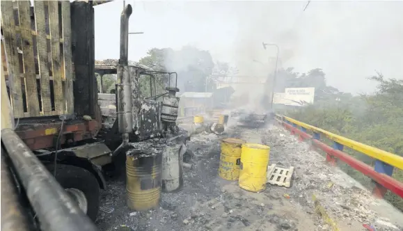  ?? (Photo: AP) ?? In this February 23, 2019 file photo, charred trucks that were part of a humanitari­an aid convoy attempting to cross into Venezuela sit parked on the Francisco de Paula Santander internatio­nal bridge in Cucuta, Colombia. A new report published on April 16, 2021, by the inspector general at the US Agency for Internatio­nal Developmen­t said the deployment of the aid was driven in part by the US’ pursuit of regime change rather than just technical analysis of the needs and best ways to help struggling Venezuelan­s.