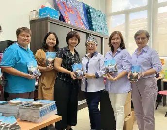  ?? ?? Dayang Mariani (third right) hands over the books to Teo, as others look on.