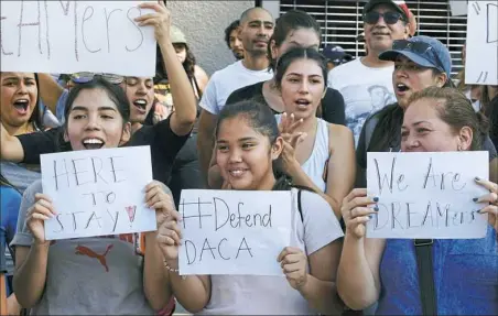  ??  ?? Supporters of the Deferred Action for Childhood Arrivals chant slogans and holds signs Monday while joining a Labor Day rally in downtown Los Angeles.