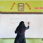  ?? MARTIN MEJIA/AP 2021 ?? Teacher Carmen Cazorla writes in the Quechua language, spoken by about 10 million people, during a class at a public primary school in Licapa, Peru.