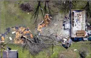  ?? Arkansas Democrat-Gazette/STEPHEN B. THORNTON ?? Pieces of a roof torn from a home in Higginson are scattered in the backyard Wednesday morning after a tornado hit the White County town Tuesday evening.