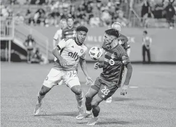  ?? JIM DEDMON USA TODAY Sports ?? Charlotte FC defender Jaylin Lindsey battles Toronto FC defender Raoul Petretta for the ball in Saturday’s first half at Bank of America Stadium.