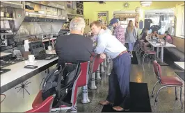  ?? GEORGE BENNETT / THE PALM BEACH POST ?? Agricultur­e Commission­er Adam Putnam, a GOP candidate for governor, talks to a customer at Howley’s restaurant in West Palm Beach.