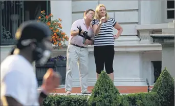  ?? LAURIE SKRIVAN — ST. LOUIS POST-DISPATCH VIA AP ?? In this June 28, 2020 file photo, armed homeowners Mark and Patricia McCloskey, standing in front their house along Portland Place, confront protesters marching to St. Louis Mayor Lyda Krewson’s house in the Central West End of St. Louis.