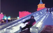  ?? ASSOCIATED PRESS ?? Visitors slide down a castle-like structure made from blocks of ice at the annual Harbin Internatio­nal Ice and Snow festival in Harbin, northeaste­rn China.