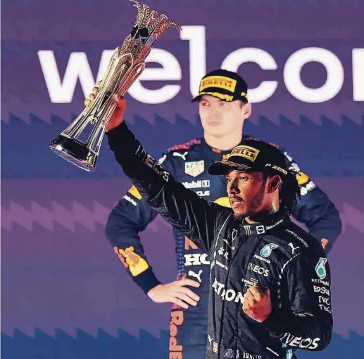  ?? Foto: AFP ?? Ein sichtlich angefresse­ner Max Verstappen verlässt die Siegerehru­ng direkt nach der Pokalüberg­abe. Lewis Hamilton freut sich.