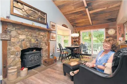  ?? AMY DAVIS/BALTIMORE SUN ?? Betty Crader and her husband were the original owners of this split-foyer home in the Stevens Forest neighborho­od of Oakland Mills. Crader’s husband, who died two years ago, built the fireplace mantel from salvaged barn wood.