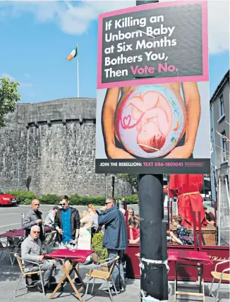  ??  ?? Niamh Crudden, left, supports the campaign to change Ireland’s abortion laws. But roads in County Roscommon, above, are dotted with anti-abortion signs