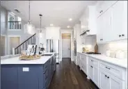  ??  ?? The glamorous kitchen provides white quartz countertop­s, stainless-steel appliances and a breakfast bar.