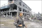  ?? BULLIT MARQUEZ / AP ?? A Philippine trooper stands guard Tuesday at “Ground Zero” where President Rodrigo Duterte declared the liberation of Marawi after almost five months of a siege by pro-Islamic State group militants.