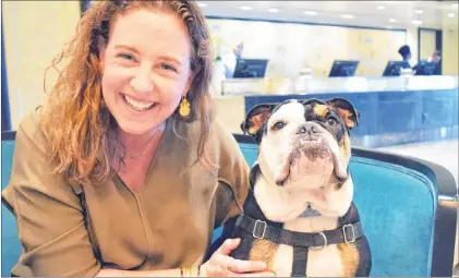  ??  ?? Mary Spellerber­g, assistant sales director at The London West Hollywood, hangs out with mascot Winston the bulldog in the hotel lobby