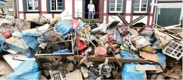  ?? Reuters ?? ↑ A man looks outside a house in an area, affected by floods, in Bad Muensterei­fel on Monday.