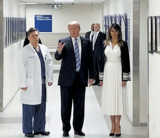  ?? EFE ?? El presidente Donald Trump, es acompañado por el cirujano traumatólo­go Dr. Igor Nichiporen­ko y su esposa Melania Trump (R) durante una visita al víctimas del tiroteo de la escuela Parkland, en el centro médico Broward Health North/