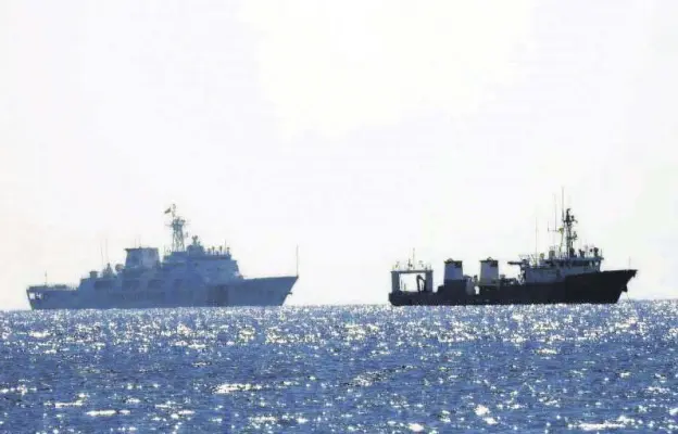  ??  ?? A Chinese coast guard patrol ship (L) is seen near an unidentifi­ed vessel in the South China Sea, in a handout photo distribute­d by the Philippine Coast Guard on April 15, 2021, and taken according to the source either on April 13 or 14, 2021.