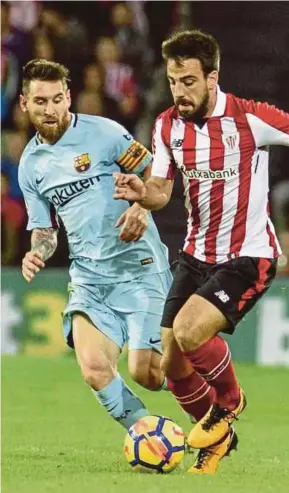  ?? EPA PIC ?? Barcelona’s Lionel Messi (left) and Athletic Bilbao’s Benat Etxebarria vie for the ball at San Mames Stadium on Saturday.